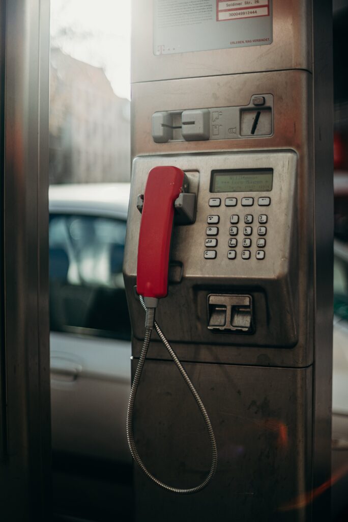 Red Telephone on Brown Wooden Table